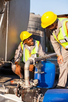 Two men chatting while working on fuel line